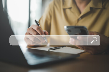 Leinwandbilder - Searching Browsing Internet Data Information with blank search bar. casual businessman working with smart phone and write note, laptop computer on desk in office. Networking Concept.