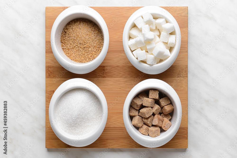 Bowls with sugar on light background