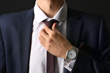 Wall Mural - Young man in stylish suit on dark background, closeup