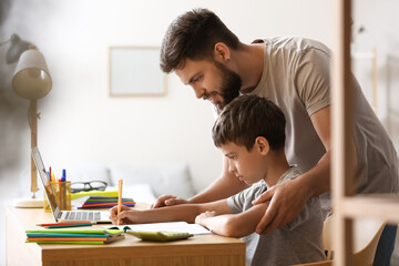 Wall Mural - Little boy with his father doing lessons at home