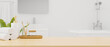© bongkarn - Wooden board or tabletop with mockup space and bath accessories over modern white bathroom interior