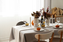 Beautiful Autumn Table Setting With Flowers And Pumpkins At Restaurant
