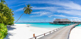 Fototapeta Sypialnia - Amazing panorama at Maldives. Luxury resort villas seascape with palm trees, white sand and blue sky. Beautiful summer landscape. Amazing beach background for vacation holiday. Paradise island concept