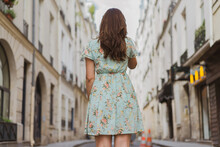 Young Woman In Floral Patterned Dress Standing On Footpath