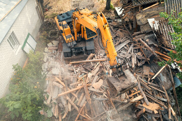 Wall Mural - Process of demolition of old building dismantling. Excavator breaking house. Destruction of dilapidated housing for new development.