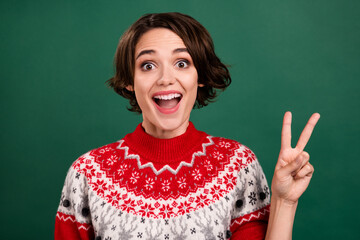 Poster - Portrait of attractive amazed cheerful girl showing v-sign having fun isolated over green color background