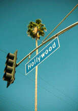 USA, California, City Of Los Angeles, Stoplight With Hollywood Sign Hanging Against Clear Turquoise Sky