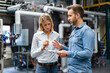 © Westend61 - Male professional explaining over equipment to female coworker at industry