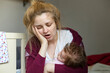 © rubchikova - Sleepy woman with baby on the bed. Tired young mom