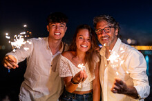 Family Enjoying Sparklers On Beach At Night