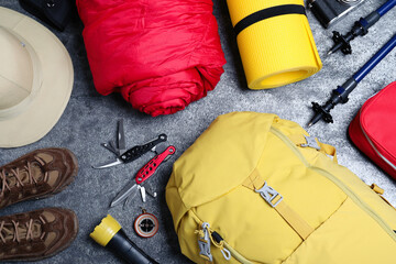 Wall Mural - Flat lay composition with backpack and other camping equipment for tourism on grey background