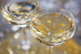 Fototapeta Kosmos - Glass of champagne with golden stars