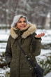 © goyoconde - happy and joyful white haired woman in the snow feeling the snow