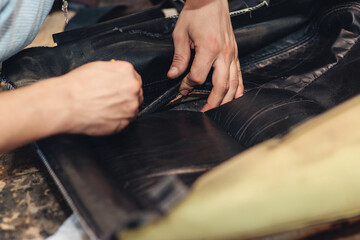 Wall Mural - Repair of the old car seat. Car mechanic's hands is using tools.