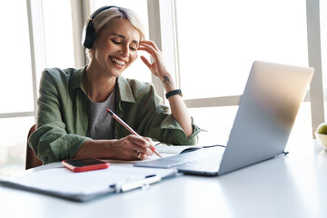 Wall Mural - Middle aged blonde woman with short hair studying