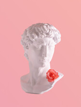 Plaster Male Head And Artificial Rose, Creative Composition Against Pastel Pink Background. Popular Culture Idea, Tourism, Consumerism, Kitsch Souvenirs, Beauty Ideal, Mockery. 