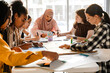 © Drobot Dean - Multiracial young feminist women making posters during meeting