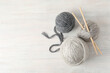 Yarn balls and knitting needles on white wooden table