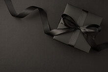 Top View Photo Of Black Gift Box With Black Ribbon Bow On Isolated Black Background With Empty Space
