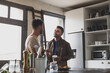 © ReeldealHD images - Hispanic gay couple in kitchen having coffee