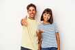 © Asier - Young mixed race couple isolated on white background stretching hand at camera in greeting gesture.