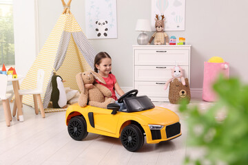 Canvas Print - Adorable child with toy driving car in room at home