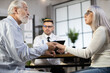 © sofiko14 - Side view of mature man and woman holding hands and looking on each other while sitting at doctor's cabinet. Excitement during medical diagnostic. Problems of ages.