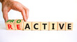 Reactive or proactive symbol. Businessman turns wooden cubes and changes the word reactive to proactive. Business and reactive or proactive concept. Beautiful white background, copy space.