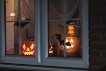 Woman witch carrying a pumpkin for Halloween night - Spooky scene with halloween symbols and signs  - holidays, culture and lifestyle in UK and United States