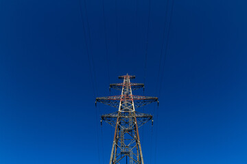 Canvas Print - Low-angle shot overhead power line against the blue sky