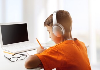 Wall Mural - Back to school. Happy little pupil at the desk. Child doing homework