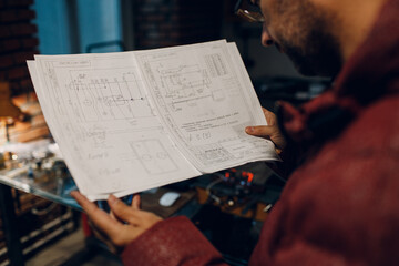 Adult young engineer working on project and hold blueprint.