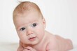 © ritiniya - small child, baby lies on his stomach and smiles. On a white background. Newborn baby. three months old baby. A baby of European appearance. selective focus