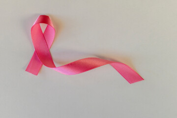 Wall Mural - pink ribbon with bow on white background. breast cancer prevention campaign. pink October.