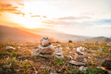 A Stone Stack With Balanced Stones On A Blurry Background Of Mountains At Sunset
