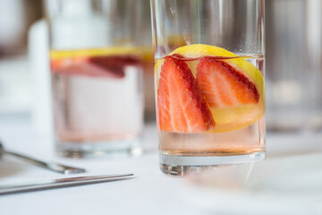 Canvas Print - Closeup shot of a cocktail with strawberries and lemon in the glass