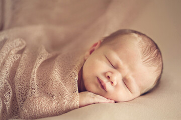 Wall Mural - A newborn baby sleeping on a soft white background. Childhood or parenting concept. Soft focus, copy space.
