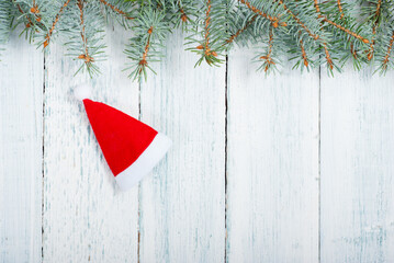 Wall Mural - Santa hat and pine tree branches frame on old wood table, Christmas background