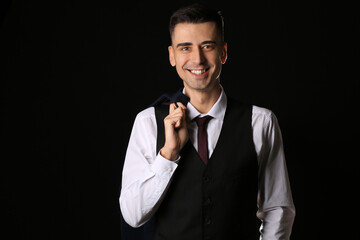 Wall Mural - Handsome young man in stylish formal suit on dark background