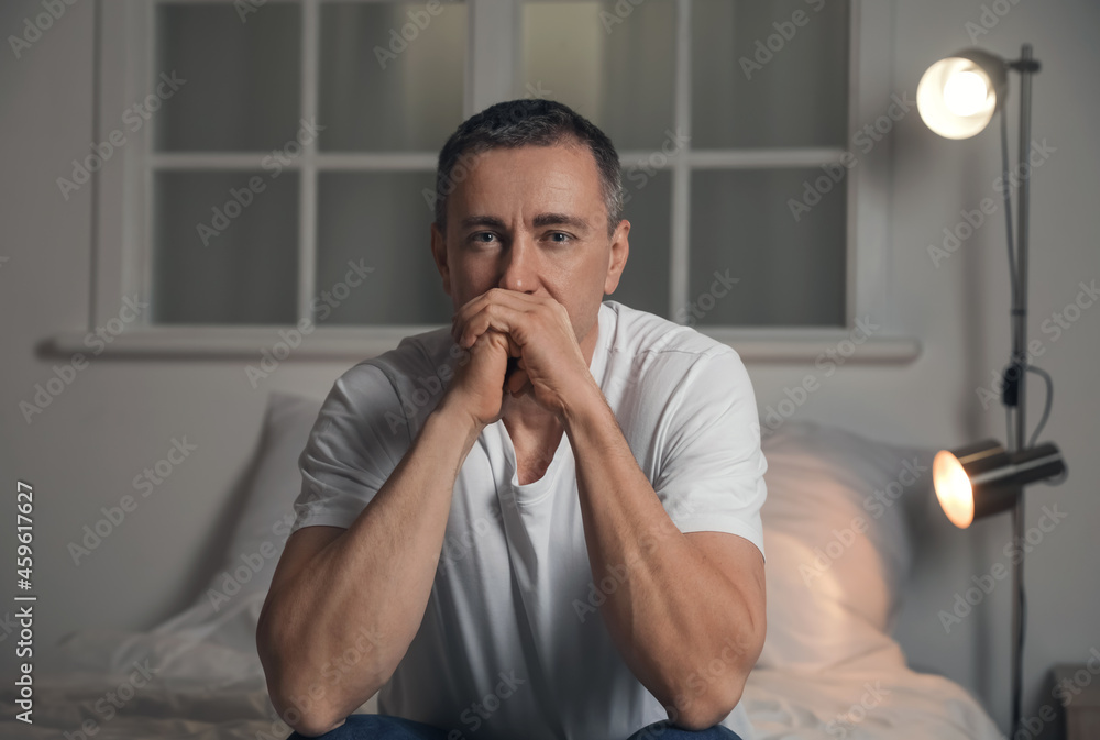 Depressed mature man in bedroom