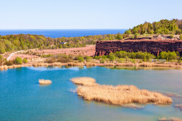 Wall Mural - Old abandoned open pit with a lake and cliff walls