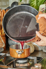 Wall Mural - Chef pours the liquid in Copper Pot over low heat on the stove to make the sauce