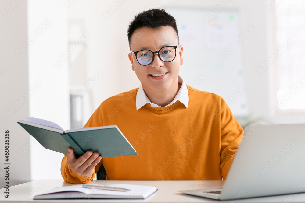 Asian teacher conducting lesson online in classroom