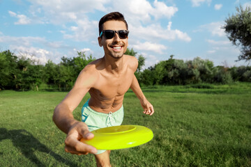 Wall Mural - Young man playing frisbee in park