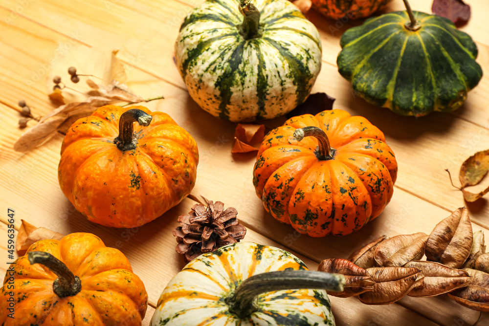 Different ripe pumpkins on wooden background, closeup