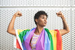 © Westend61 - Young lesbian woman flexing muscles with rainbow flag