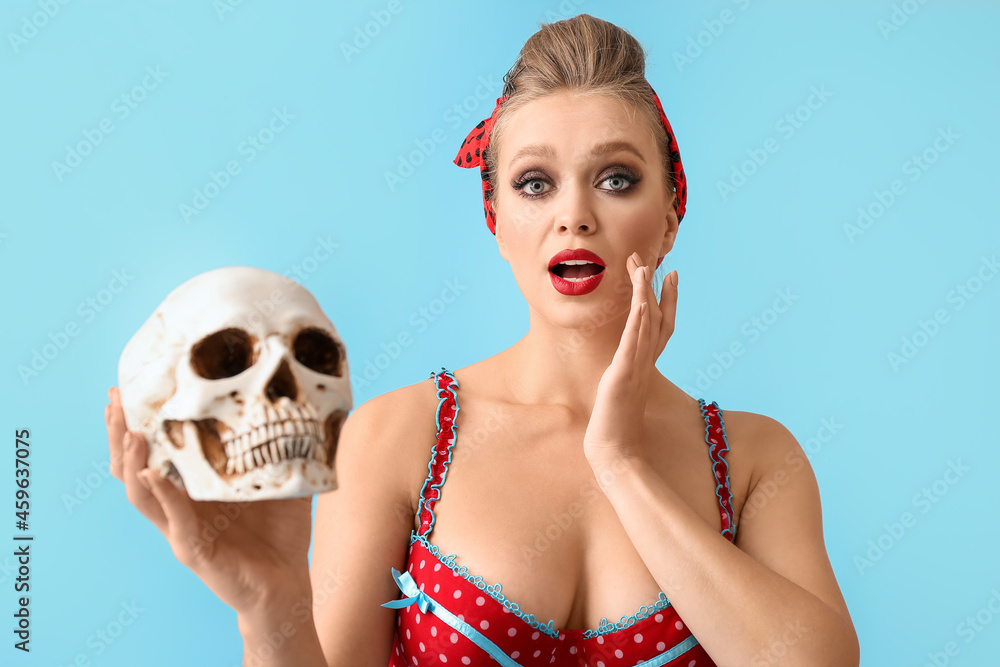 Sexy young woman with skull on color background