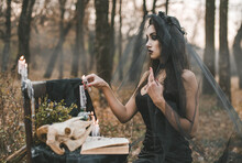 Brunette Witch Girl Conjures In The Forest Conducts Rituals With A Fantasy Skull Nature Magic In Fire Halloween