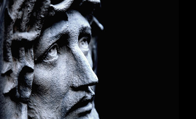 Fototapete - Jesus Christ in profile against dark background. Ancient statue. Copy space. Horizontal image.