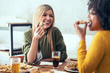 Female Friends Eating Pizza In Restaurant
